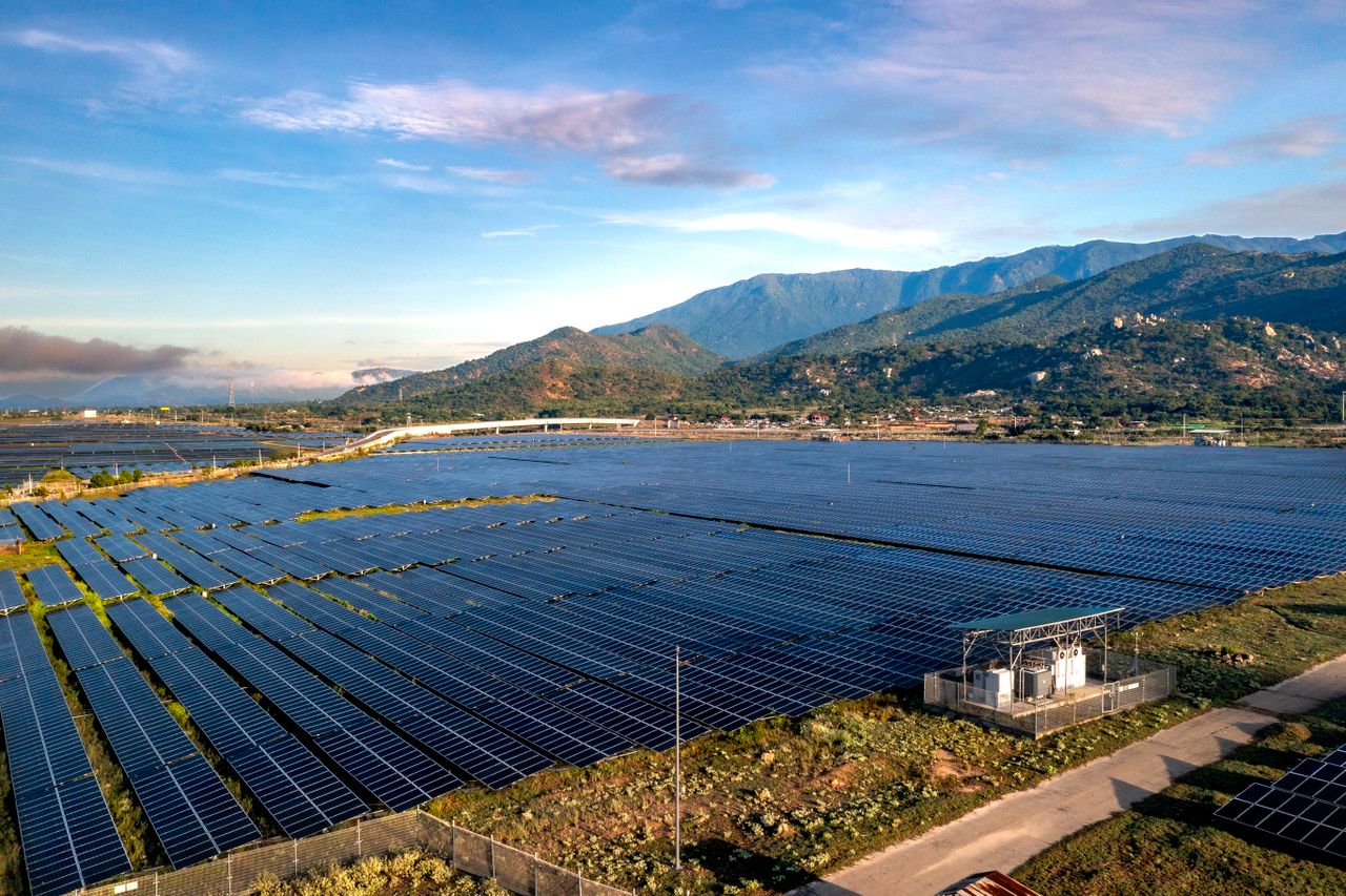 services-03 Aerial view of a large solar farm with mountainous background in Ninh Thuan, Vietnam.